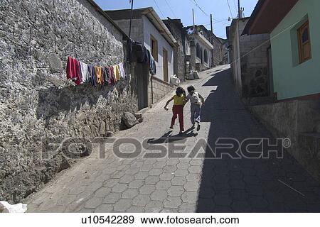 Stock Photo -  guatemala two girls running up street san pedro. Fotosearch