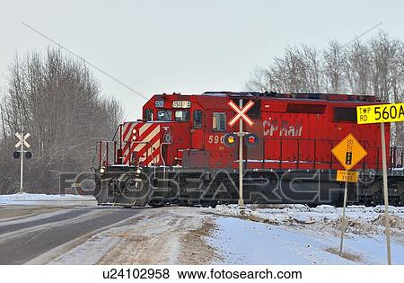 Stock Photo -  image engine freight train crossing roadway flat. Fotosearch