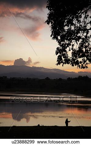 Stock Photo -  man guatemala sunset over lake lemoa el quiche . Fotosearch