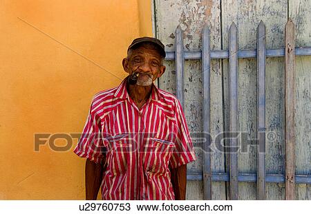 Stock Image -  man old portrait in trinidad cuba red shirt pipe. Fotosearch