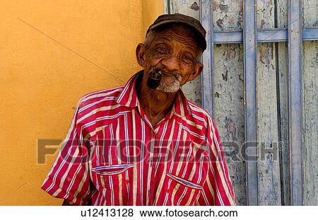 Stock Photo -  man old portrait in trinidad cuba red shirt pipe. Fotosearch