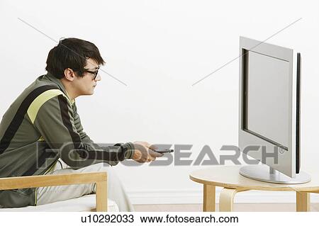 Stock Image -  man side profile young sitting chair watching. Fotosearch