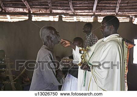 Stock Image -  man south sudan catholic mass in simple mud man. Fotosearch