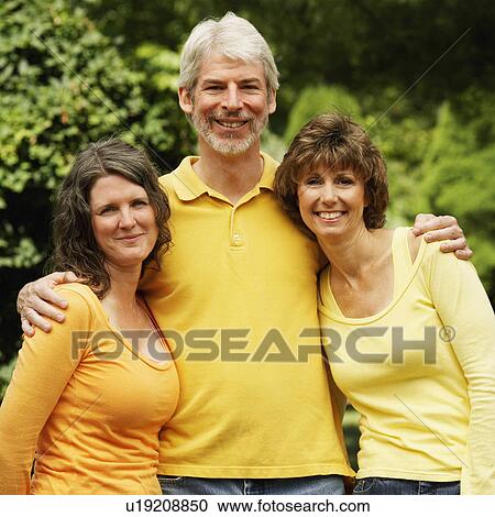 Stock Image -  man women two mature standing in park smiling. Fotosearch