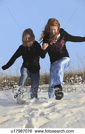 Stock Photograph -  nature winter young girls playing in snow canada. Fotosearch