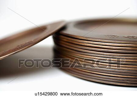 Stock Image -  people closeup stack bronze plates color image. Fotosearch