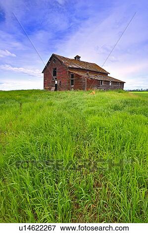 Stock Photo -  summer old abandoned red barn sits top hill . Fotosearch
