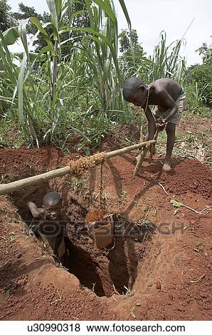 Stock Photo -  uganda boys digging pit latrine hauling up dirt . Fotosearch
