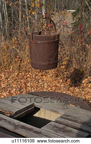 Stock Photo -  vintage image pioneer wooden bucket hanging pipe. Fotosearch