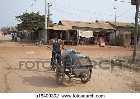 Stock Image -  water people man cambodia wheeling drum drinking . Fotosearch