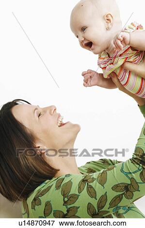 Stock Photo -  woman baby child side profile mid adult picking. Fotosearch