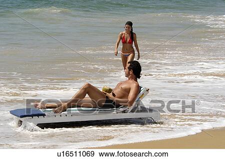 Stock Photo -  woman beach water couple in mulloor kovalam. Fotosearch