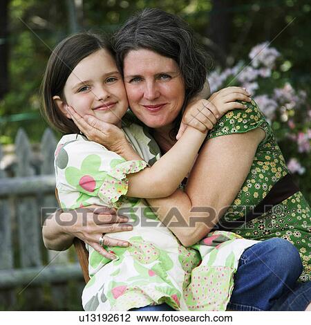 Stock Image -  woman child portrait mature daughter hugging 8-9 years. Fotosearch
