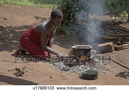 Stock Image -  woman food house fire women uganda young cooking . Fotosearch