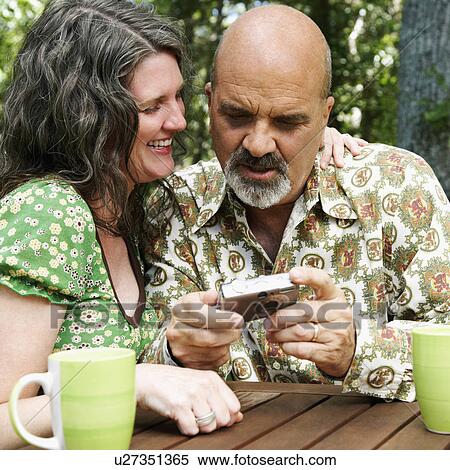 Stock Photography -  woman food man mature holding digital camera arm. Fotosearch