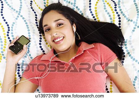 Stock Photo - woman portrait young listening mp3 player 20-24 years. Fotosearch