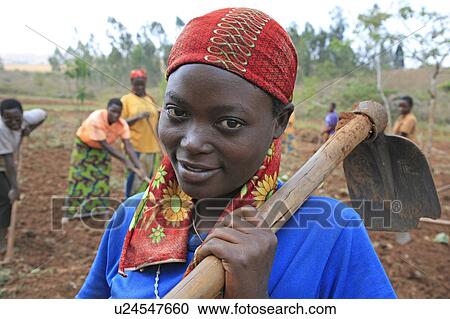Stock Image -  woman women burundi carrying hoe gitera africa . Fotosearch