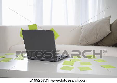 Stock Image - Adhesive notes scattered on table with laptop. Fotosearch