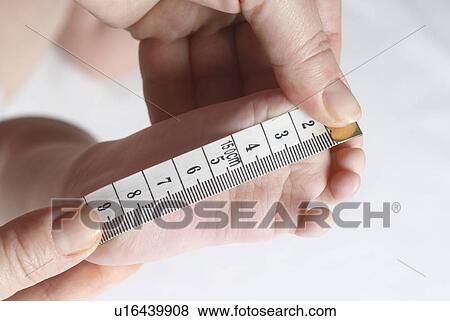 Adult measuring foot of baby (6-12 months), close up of hands View Large Photo Image Stock Photo - Adult measuring foot of baby (6-12 months), close up of hands. Fotosearch