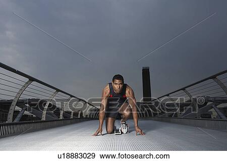 Athlete crouching at starting blocks on footbridge, Millennium Bridge, London, England View Large Photo Image Stock Photo - Athlete crouching at starting blocks on footbridge, Millennium Bridge, London, England. Fotosearch