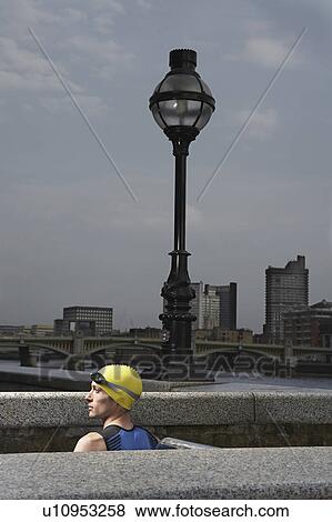 Athlete standing between river embankment ledges, London, England View Large Photo Image Stock Photo - Athlete standing between river embankment ledges, London, England. Fotosearch