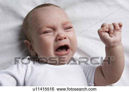 Baby (1-6 months) lying on bed, crying, portrait View Large Photo Image Stock Photograph - Baby (1-6 months) lying on bed, crying, portrait. Fotosearch