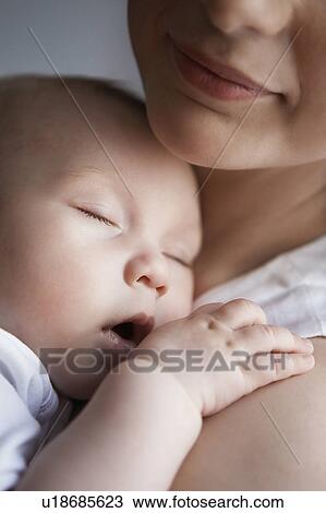 Baby (1-6 months) sleeping on mother's chest, close up View Large Photo Image Stock Image - Baby (1-6 months) sleeping on mother's chest, close up. Fotosearch