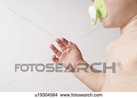 Baby (6-12 months) with pacifier, mid section View Large Photo Image Picture - Baby (6-12 months) with pacifier, mid section. Fotosearch