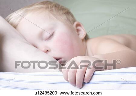 Stock Photo - Baby boy lies sleeping. Fotosearch