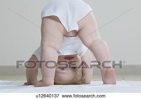 Baby girl playing on floor, upside-down View Large Photo Image Stock Photo - Baby girl playing on floor, upside-down. Fotosearch