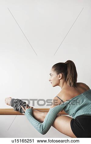 Stock Image - Ballet Dancer stretching at bar. Fotosearch
