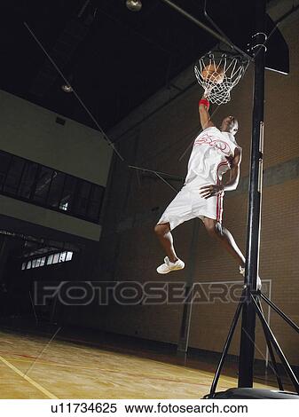 Basketball player slam dunking, low angle view View Large Photo Image Stock Photography - Basketball player slam dunking, low angle view. Fotosearch