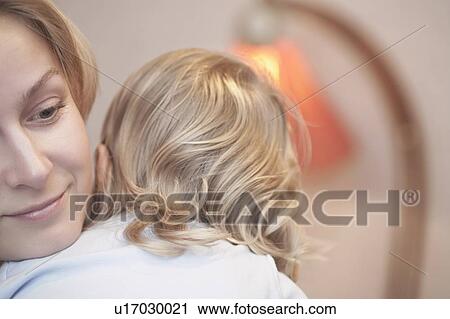 Blonde mother holds toddler over shouldre View Large Photo Image Stock Image - Blonde mother holds toddler over shouldre. Fotosearch