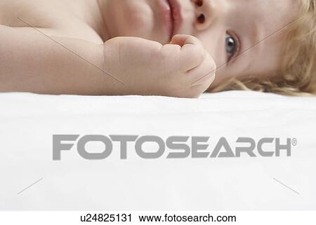 Stock Image - Boy (1-2 years) lying down. Fotosearch