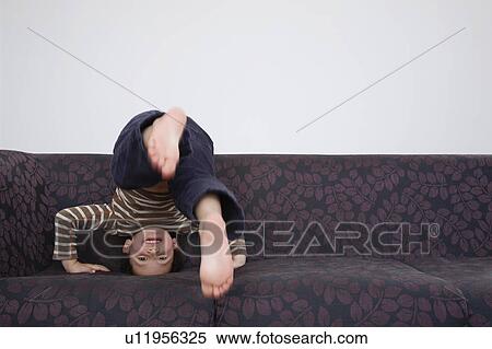 Boy (5-6) doing forward roll on sofa View Large Photo Image Stock Photography - Boy (5-6) doing forward roll on sofa. Fotosearch