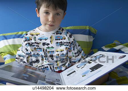 Boy (5-6) sitting in bed, reading book, portrait View Large Photo Image Picture - Boy (5-6) sitting in bed, reading book, portrait. Fotosearch