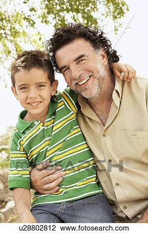 Boy (7-9) sitting on knee of grandfather, portrait. View Large Photo Image Stock Image - Boy (7-9) sitting on knee of grandfather, portrait.. Fotosearch