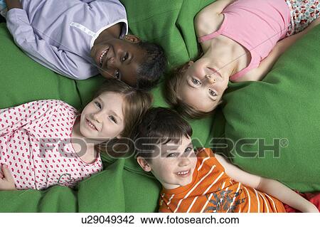 Boy and three girls (5-7) lying on back, portrait, view from above View Large Photo Image Stock Image - Boy and three girls (5-7) lying on back, portrait, view from above. Fotosearch
