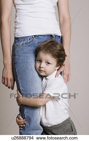 Picture - Boy hugging his mothers leg. Fotosearch