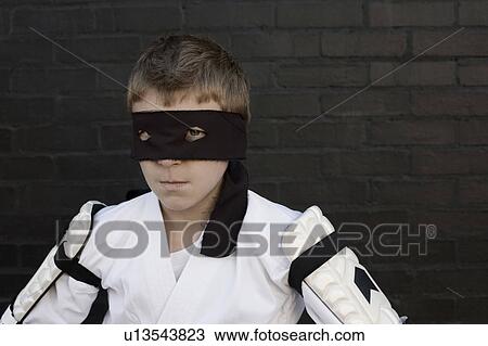 Stock Image - Boy wearing Zorro blindfold and fencing costume. Fotosearch