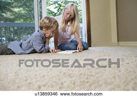Brother and sister (5-9) reading book on carpet View Large Photo Image Stock Photograph - Brother and sister (5-9) reading book on carpet. Fotosearch
