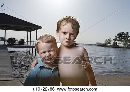 Stock Photograph - Brothers Standing on Pier. Fotosearch