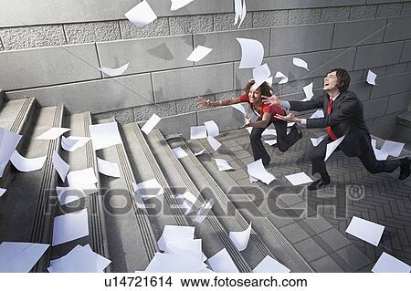 Busines man and woman catching falling paperwork on steps View Large Photo Image Picture - Busines man and woman catching falling paperwork on steps. Fotosearch