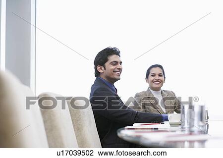 Stock Image - Business associates smiling having business meeting. Fotosearch