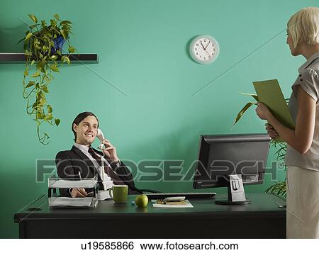 Stock Photograph - Business man and business woman in office. Fotosearch