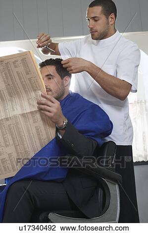 Business man reading newspaper, barber cutting hair in barber shop View Large Photo Image Stock Image - Business man reading newspaper, barber cutting hair in barber shop. Fotosearch
