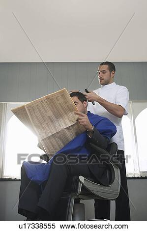 Business man reading newspaper, barber cutting hair in barber shop View Large Photo Image Stock Photography - Business man reading newspaper, barber cutting hair in barber shop. Fotosearch