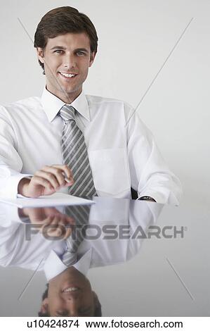Business man sitting at conference table, portrait View Large Photo Image Picture - Business man sitting at conference table, portrait. Fotosearch