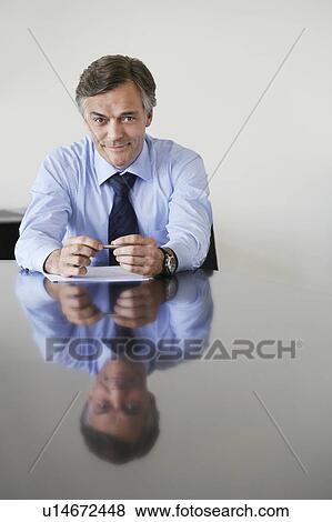 Business man sitting at conference table, portrait View Large Photo Image Stock Photo - Business man sitting at conference table, portrait. Fotosearch