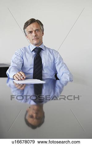Business man sitting at conference table, portrait View Large Photo Image Stock Photo - Business man sitting at conference table, portrait. Fotosearch
